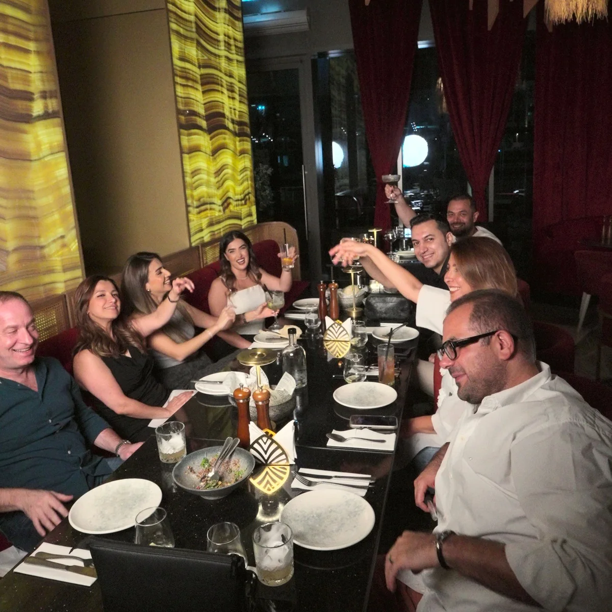 A table of friends cheering at OCCO Business Bay