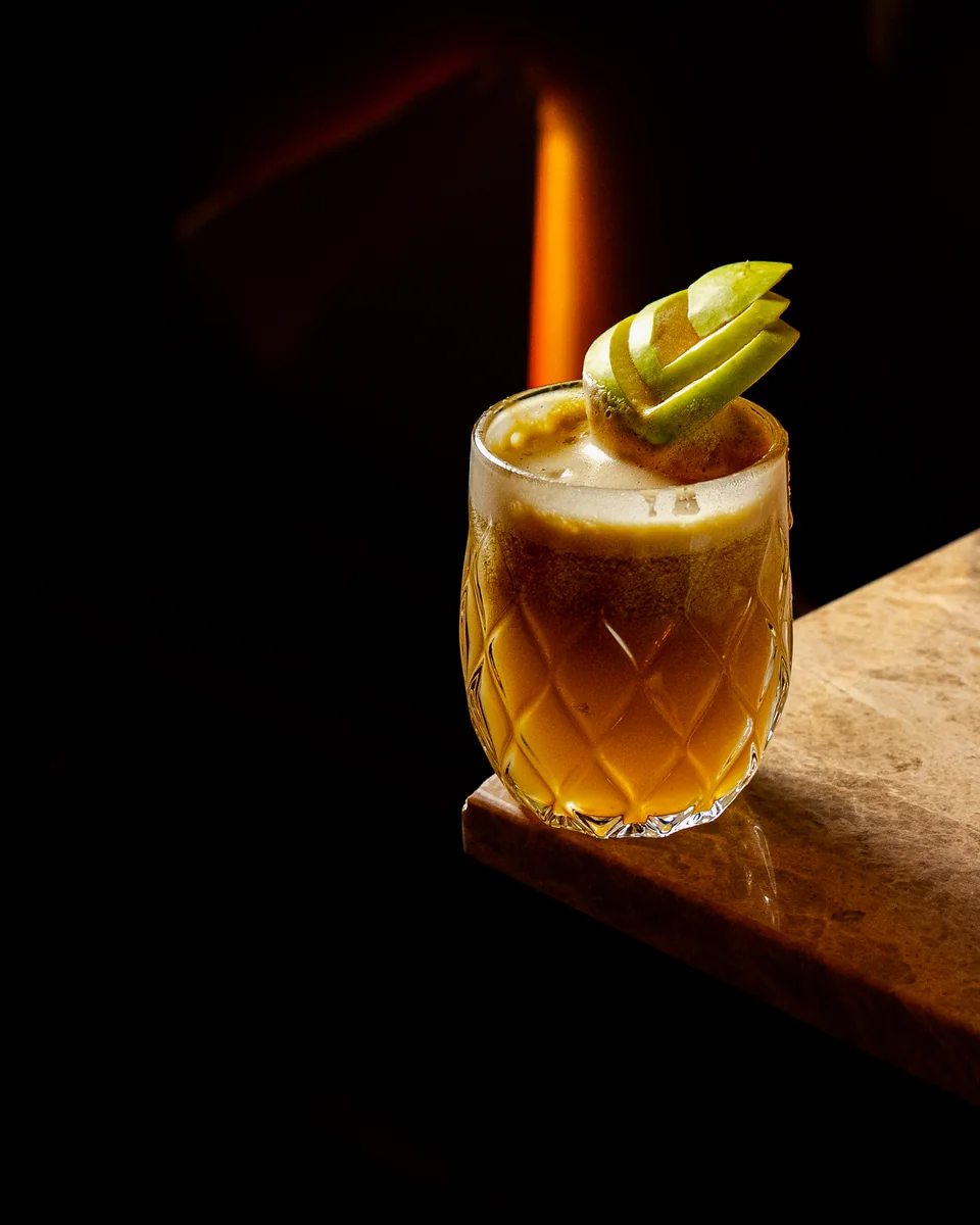 An amber mocktail with an apple fan garnish at OCCO Hessa